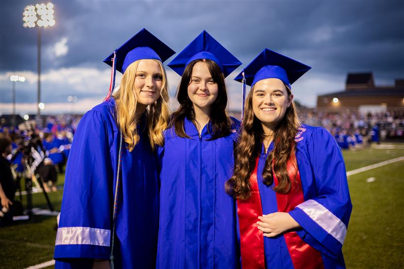 Students in blue robes graduate